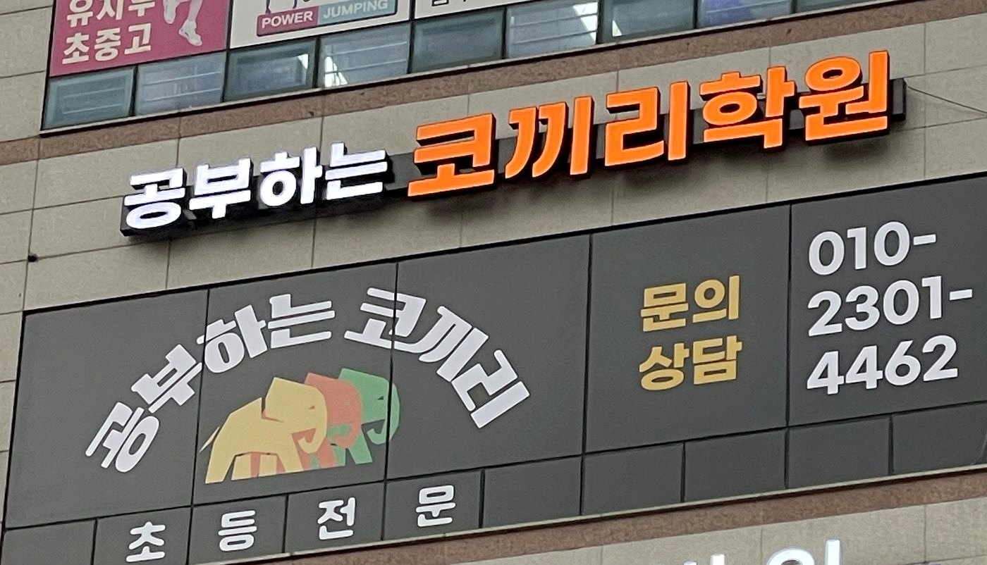 공부하는코끼리수학 건물 외벽 간판. 공부하는 코끼리학원 간판이 걸려 있고, 아래에 코끼리 로고와 초등 전문, 문의 상담 010-2301-4462가 함께 표시되어 있다.